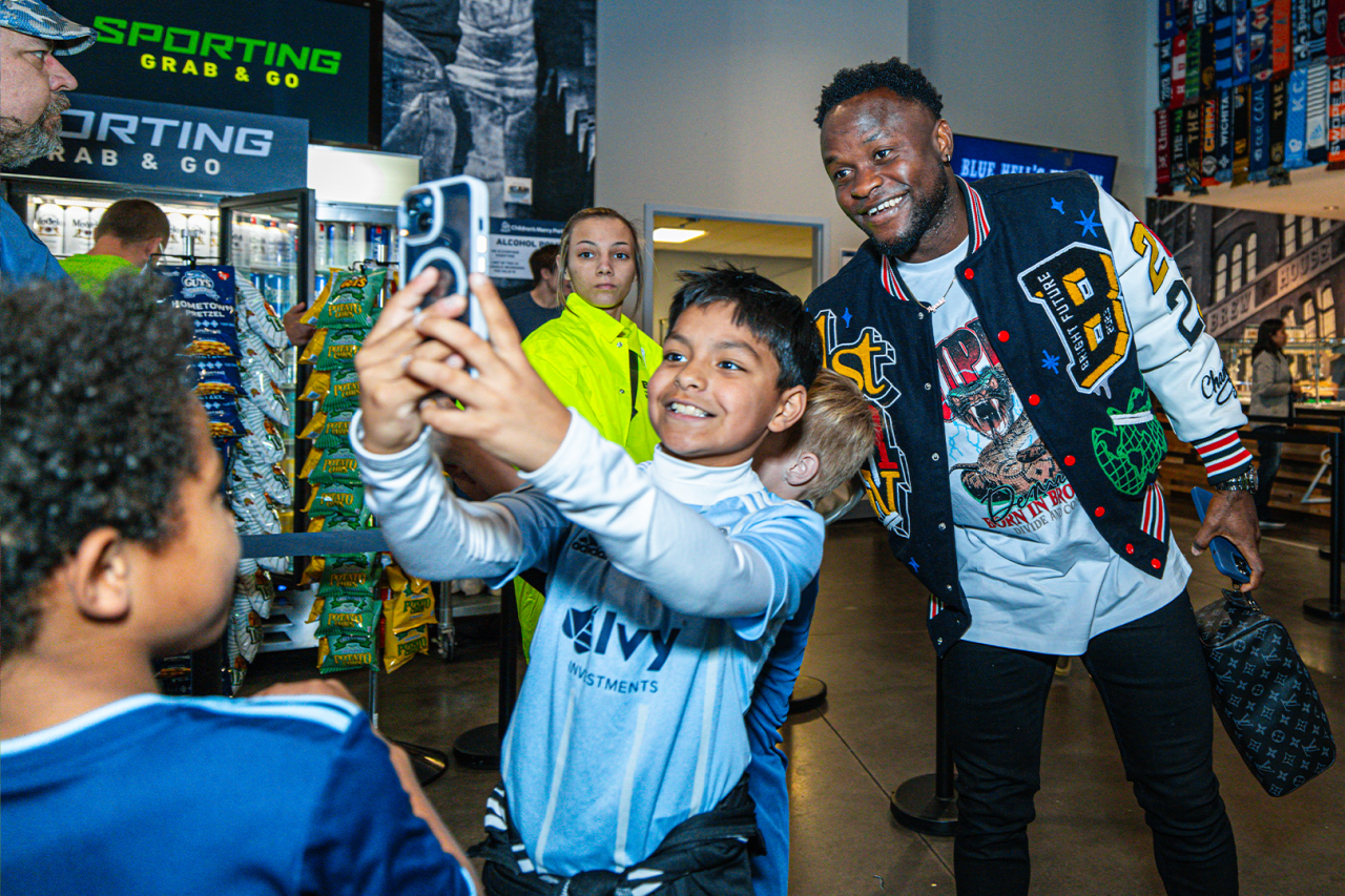 Forward, Willy Agada takes a photo with fans as he arrives to Children's Mercy Park